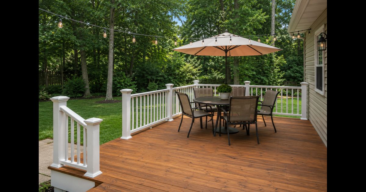 Beautiful finished backyard deck with stained wood, patio furniture and string lights